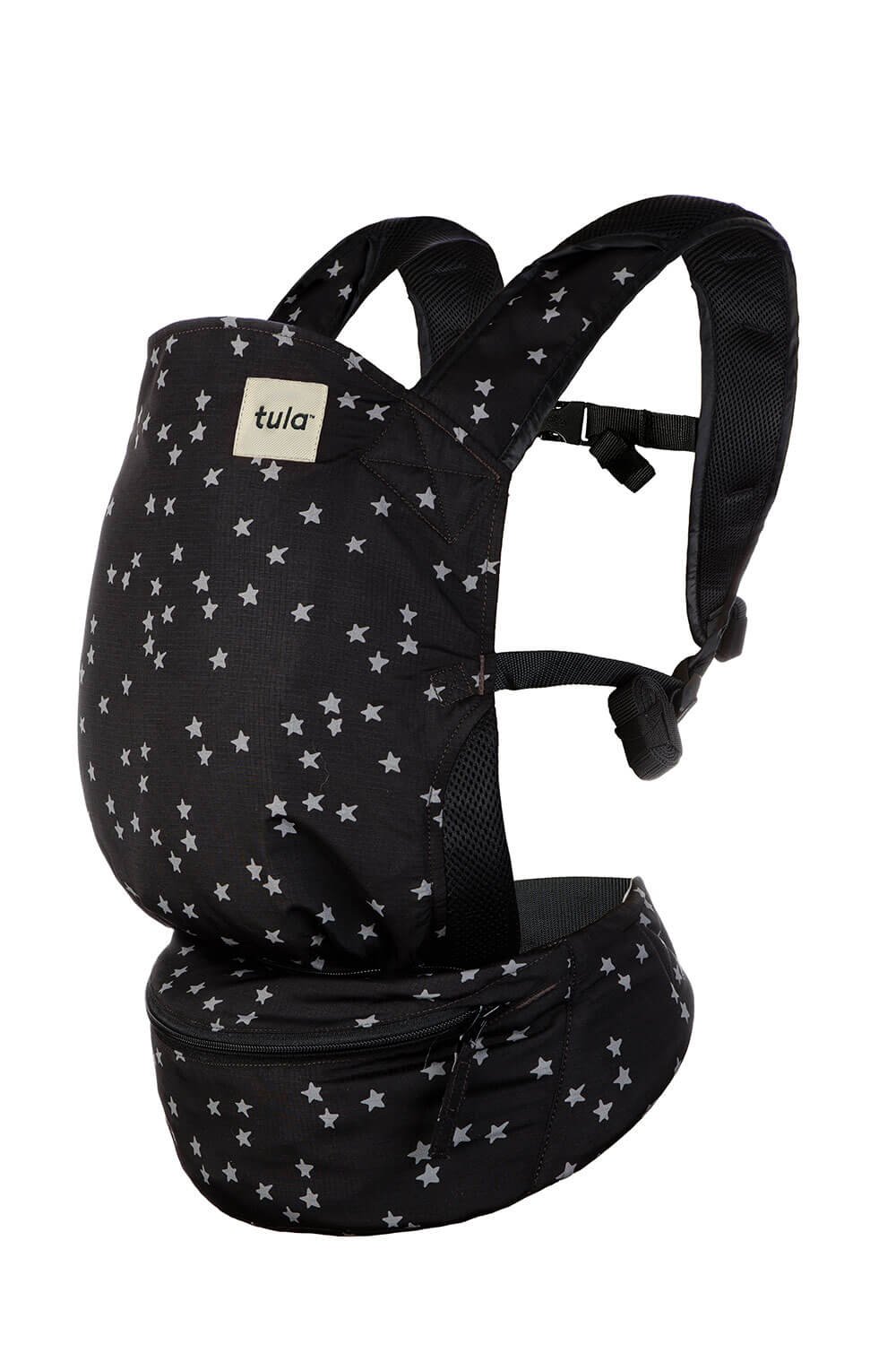 Tula Lite Compact Baby Carrier in black with a scattered white star pattern, featuring a lightweight design, padded shoulder straps, and a zippered waistband pouch for easy storage when traveling or on the go.