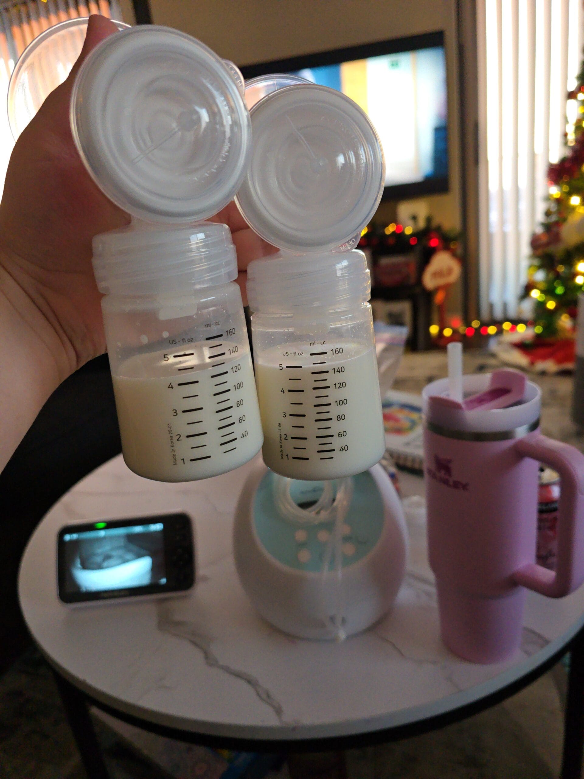 Power Pumping Schedule That Increased My Supply 4 Holding up two full breast pump bottles of pumped breast milk after power pumping to increase milk supply