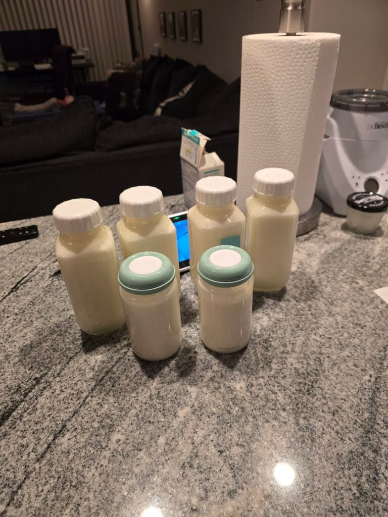 Power Pumping Schedule That Increased My Supply 12 Six bottles of pumped breast milk lined up on a kitchen counter after a power pumping schedule session